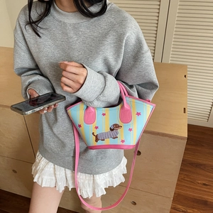 Mini dachshund bucket bag with blue and yellow stripes and pink handles shown on model