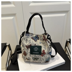 Close-up of floral butterfly jacquard bucket bag with adjustable black shoulder strap