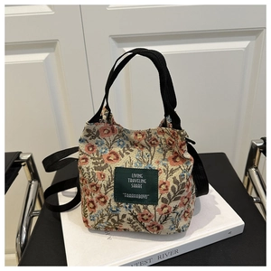 Detailed close-up of floral bucket bag with red and blue pattern and green brand label