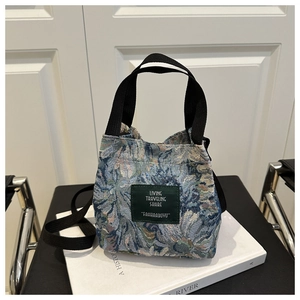 Detail of vintage floral jacquard bucket bag on white books with black strap