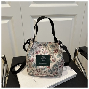 Detailed macro view of the ethnic floral bucket bag with green leather patch