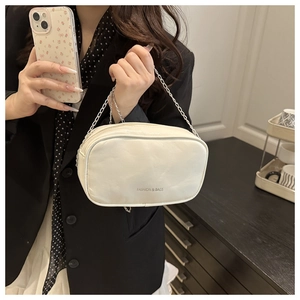 Detail of cream white PU leather mini makeup bag with silver chain strap and silver text