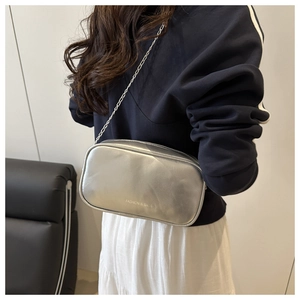 Sac bandoulière argenté métallisé avec chaîne, vue latérale élégante sur un mannequin