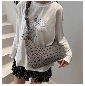 Détail du sac hobo à carreaux avec motifs de nœuds et bandoulière plissée élégante