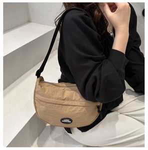 Close-up of khaki nylon crescent bag with adjustable black strap and Lucky Fashion logo