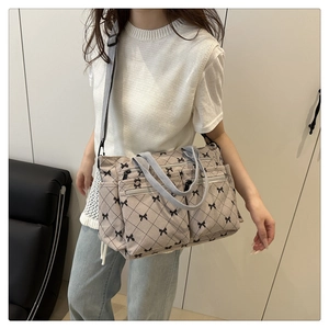 Détail du sac cabas en velours côtelé avec motif nœud noir et poches zippées pratiques