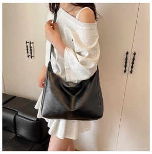 Dettaglio ravvicinato della borsa hobo nera in morbida ecopelle con texture plissettata