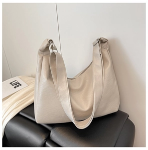 Dettaglio della borsa hobo beige minimalista con trama a grana di litchi di qualità