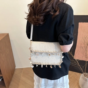 Handmade woven straw bag with seashell tassels and pearls for summer vacation style