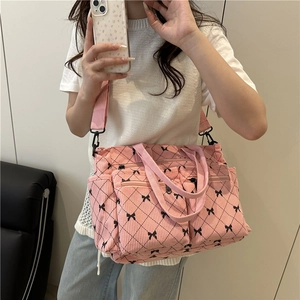 Borsa a tracolla in velluto rosa con motivi a fiocco nero e design multitasche funzionale
