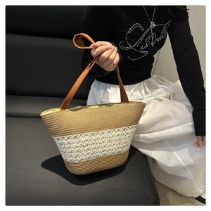 Detail der gewebten Strohtasche mit khakifarbener Streifung und braunem Ledergriff