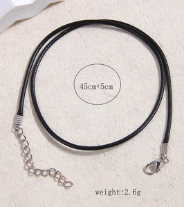 Detalle de un collar de cordón encerado negro de 45 cm con cierre de mosquetón plateado y cadena