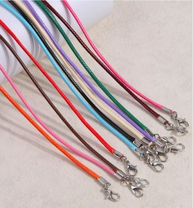 Detalle de collares de cordón trenzado de colores con cierres de mosquetón plateados