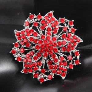 Detailed macro view of the silver flower brooch with vibrant red crystal pavé petals