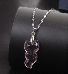 Detalle del colgante de zorro en jade rosa translúcido sobre una fina cadena de plata
