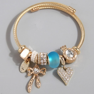 Bracciale in filo d'acciaio dorato con ciondoli a cuore e fiocco e perle di vetro blu