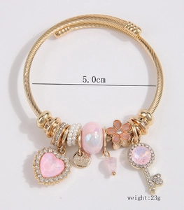 Close-up of heart and key charms on a 5.0cm gold-plated rope texture bracelet