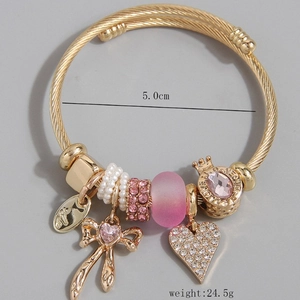Bracciale dorato con ciondoli a cuore rosa, fiocco, corona e perle di vetro