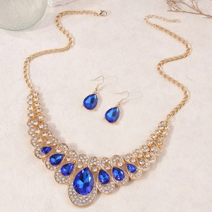 Luxurious gold jewelry set with pear-cut navy blue gemstones and white rhinestones