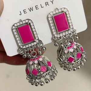 Detailed shot of ethnic silver jhumka earrings with pink enamel and bell pendants