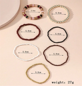 Detail of 7-piece bohemian beaded bracelet set in gold, black, and burgundy tones