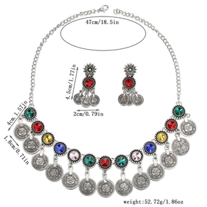 Détail d'une parure de bijoux bohème en argent avec pièces de monnaie et cristaux colorés