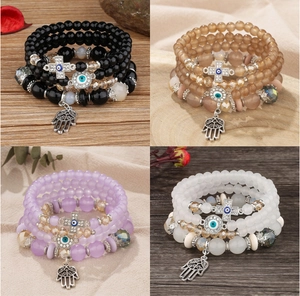 Detailed view of four bohemian beaded bracelet sets featuring Hamsa Hand and Evil Eye charms