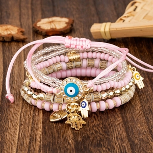 Detail of pink beaded evil eye bracelet set with Fatima hand and Love heart charm