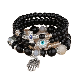 Stack of 4 black beaded bracelets with Evil Eye cross and Hamsa hand charms for women