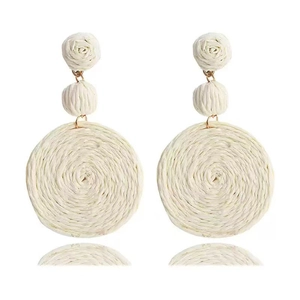Detail of cream raffia bohemian drop earrings with woven flowers and circular pendants