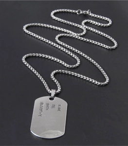 Close-up of customizable shield necklace with name, tel, and blood type engraving details