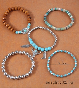Detail of 5-piece bohemian multi-layered bracelets with turquoise and metal charms