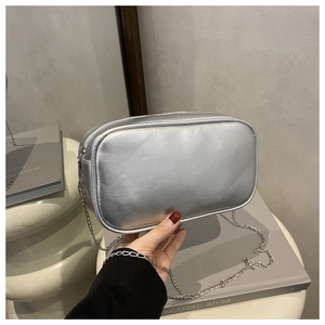 Detail of silver metallic leather crossbody bag with chain strap and sleek rectangle shape