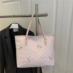Sac cabas rose avec matelassage en losanges et broderies papillons colorées sur porte