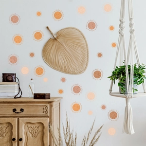 Detail of bohemian sun wall decals in orange-brown tones on white wall interior