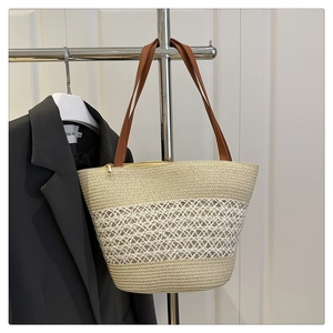 Detail der handgewebten Strohtasche mit braunen Lederriemen und goldenem Reißverschluss