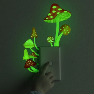Glow in the dark mushroom stickers glowing green around a power switch in the dark