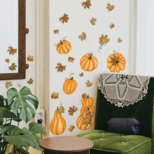 Detail of autumn pumpkin and maple leaf wall stickers on a cozy living room wall