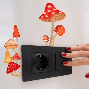 Close-up of matte black EU socket with mushroom wall sticker on a white wall