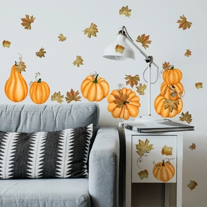 Detail of pumpkin and maple leaf wall stickers on a modern white cabinet and gray sofa