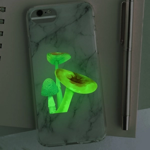 Close-up of glow-in-the-dark mushroom pattern on marble texture iPhone phone case