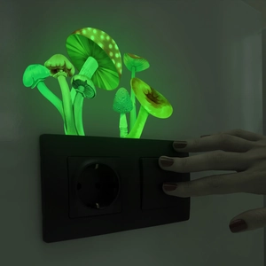 Luminous green mushroom wall sticker glowing on a black switch plate in the dark