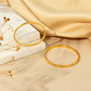 Lot de deux bracelets en acier doré poli avec bords dentelés sur fond de marbre élégant