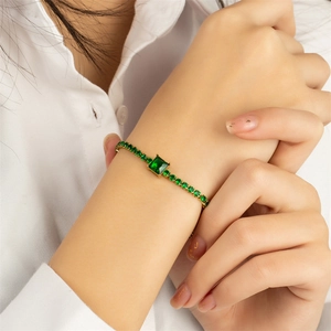 Elegant gold plated stainless steel bracelet featuring green zircon gemstones on wrist
