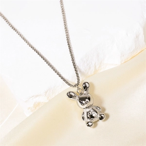 Collier avec pendentif lapin en argent minimaliste avec détails texturés sur fond en tissu