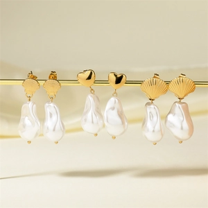 Detailed view of baroque pearl earrings with golden shell and heart design elements