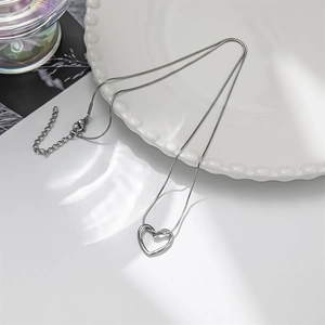Minimalist silver heart pendant necklace with hollow design and sleek snake chain
