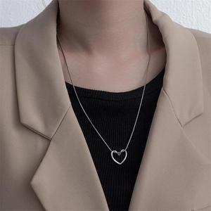 Minimalist silver heart pendant necklace in polished titanium steel worn on a model