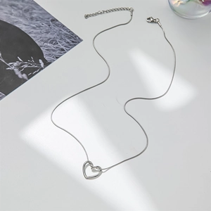 Detailed view of minimalist silver hollow heart pendant on a delicate snake chain