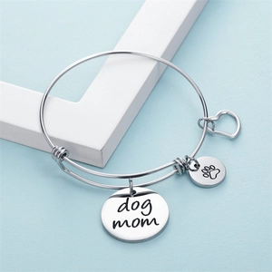Bracelet ajustable Dog Mom argenté avec breloques patte et cœur sur fond bleu clair